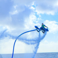 ジェットベイダーで海の上を飛ぶ男性